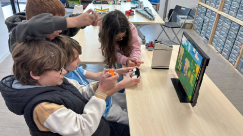 Animation LEGO Masters vacances avec un groupe d'enfants créant un décor de film en briques face à un écran de studio.