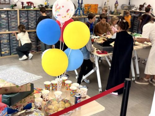 Enfants s'amusant autour de tables de construction lors d'une animation anniversaire enfant LEGO dans l'atelier privatisé de Salon-de-Provence.