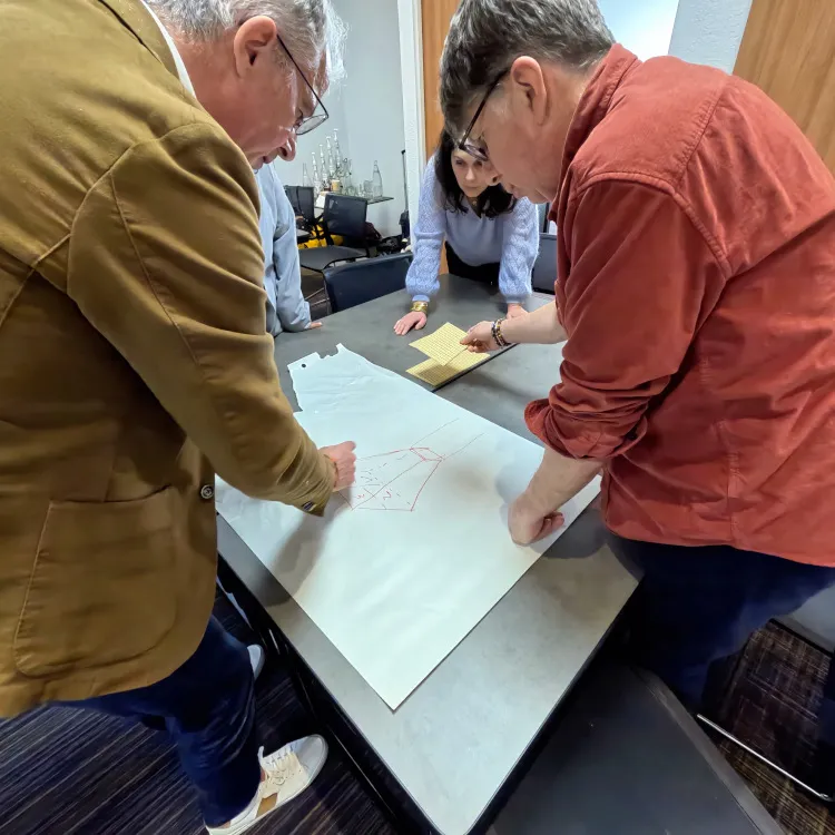 Collaborateurs en pleine réflexion autour d'un plan lors d'une organisation de séminaire entreprise original à Lyon.