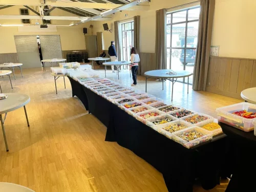 Grande salle de réception préparée avec des dizaines de bacs de briques pour l'organisation d'un séminaire d'entreprise à Paris.
